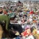 Waste pickers sorting through a large landfill filled with discarded plastic and other waste.