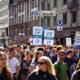 Climate protesters march through a city street holding “There Is No Planet B” placards during a climate change demonstration.