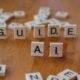 Wooden letter tiles spelling “GUIDE AI” on a table, representing AI governance and safety