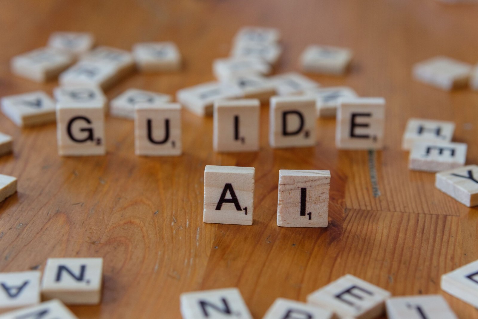 Wooden letter tiles spelling “GUIDE AI” on a table, representing AI governance and safety